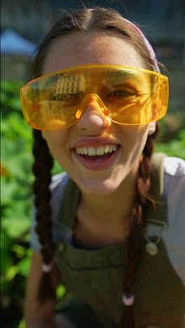 teenage girl with yellow safety glasses in a garden