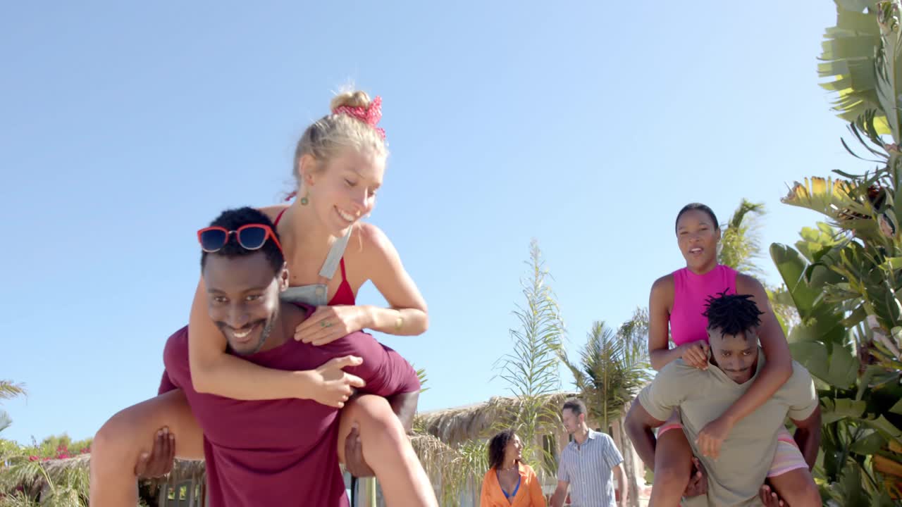 ⁇ 나무와 해변 집과 함께 해변에서 걸어서 운반하는 다양한 친구들의 행복한 그룹