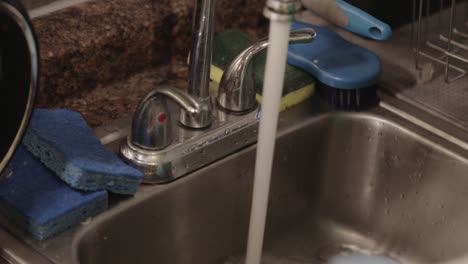 Wet-A-Dry-Sponge-WIth-Running-Water-From-The-Faucet---Close-Up-Shot