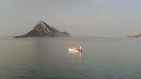 Velero-Frente-A-La-Isla-De-Tavolara-En-Cerdeña-Vista-Aérea-Durante-La-Puesta-De-Sol