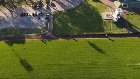 Race-Horses-running-on-racetrack-during-competition-in-stadium-of-Buenos-Aires,Argentina---Aerial-top-down-shot