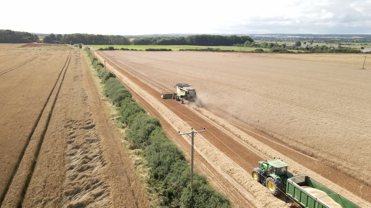 밀 작물 을 수확 하는 수확기 와 트랙터 의 공중 촬영