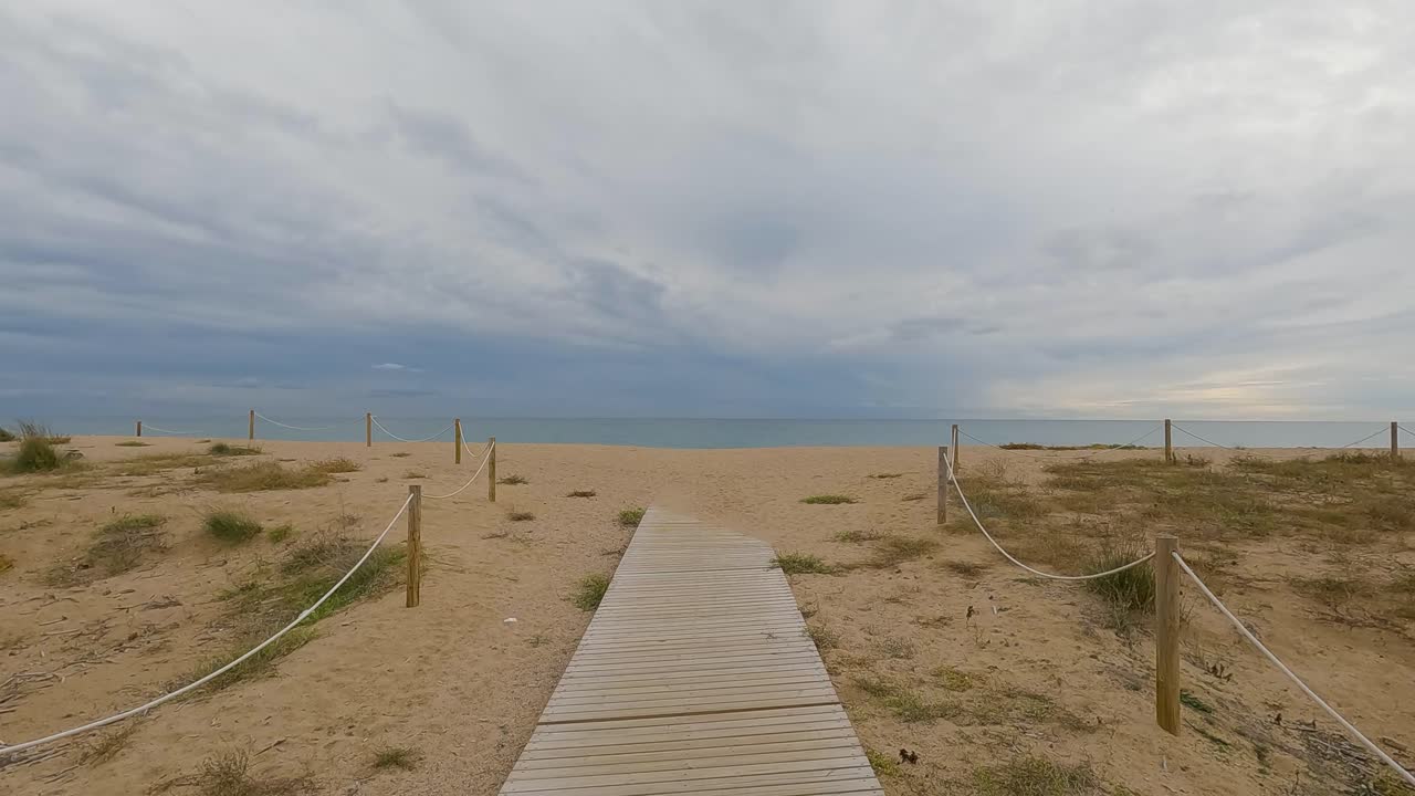 ola de mar de playa de arena gruesa en cámara lenta a 120fps 4k día nublado agua turquesa olas de mar individuales gran playa vacía