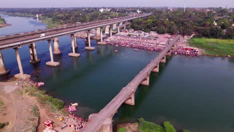 narmada ghat with gathering or mela and tilwara narmada river bridge at jotpur, jabalpur, madhya pradesh, india. day time, semi orbit, drone shot, 4k.