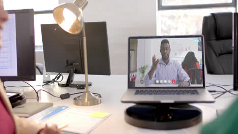 portátil con videollamada con un hombre de negocios afroamericano en la pantalla