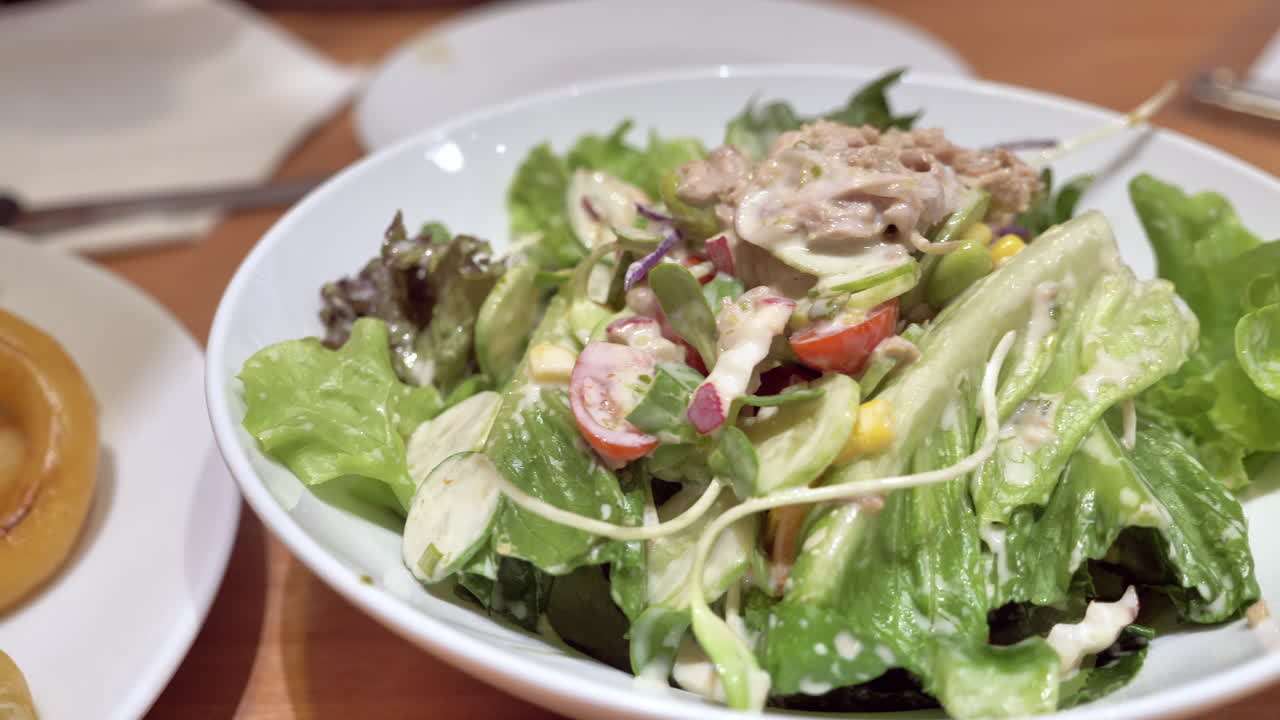 Panning from the right to the left on a platter of vegetable-tuna salad, served in a restaurant in Bangkok, Thailand