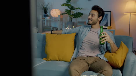 una pareja relajándose en casa viendo la televisión.