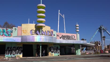 an abandoned and graffiti covered game arcade at an amusement park presents a spooky and haunted image 1