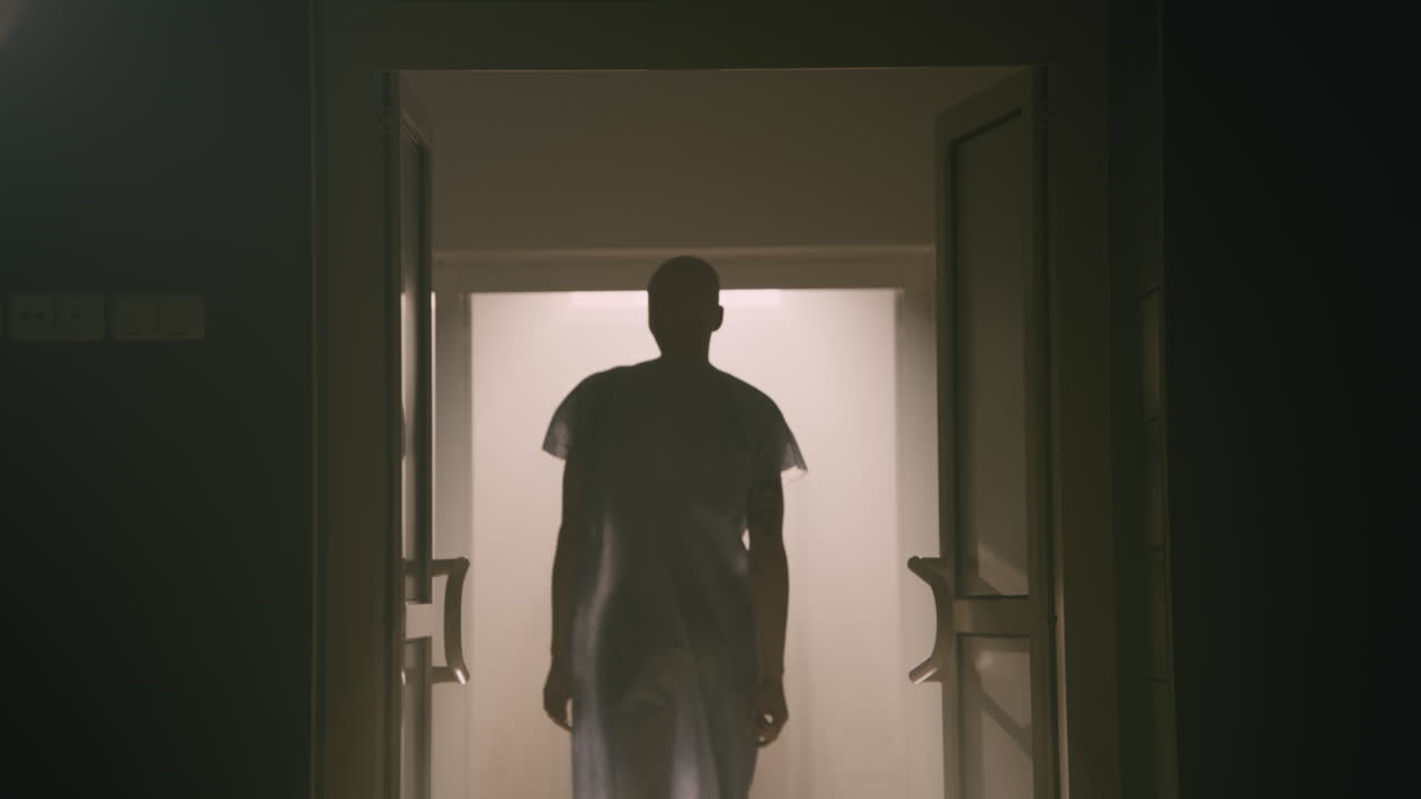 A bald man walks out the empty operation room