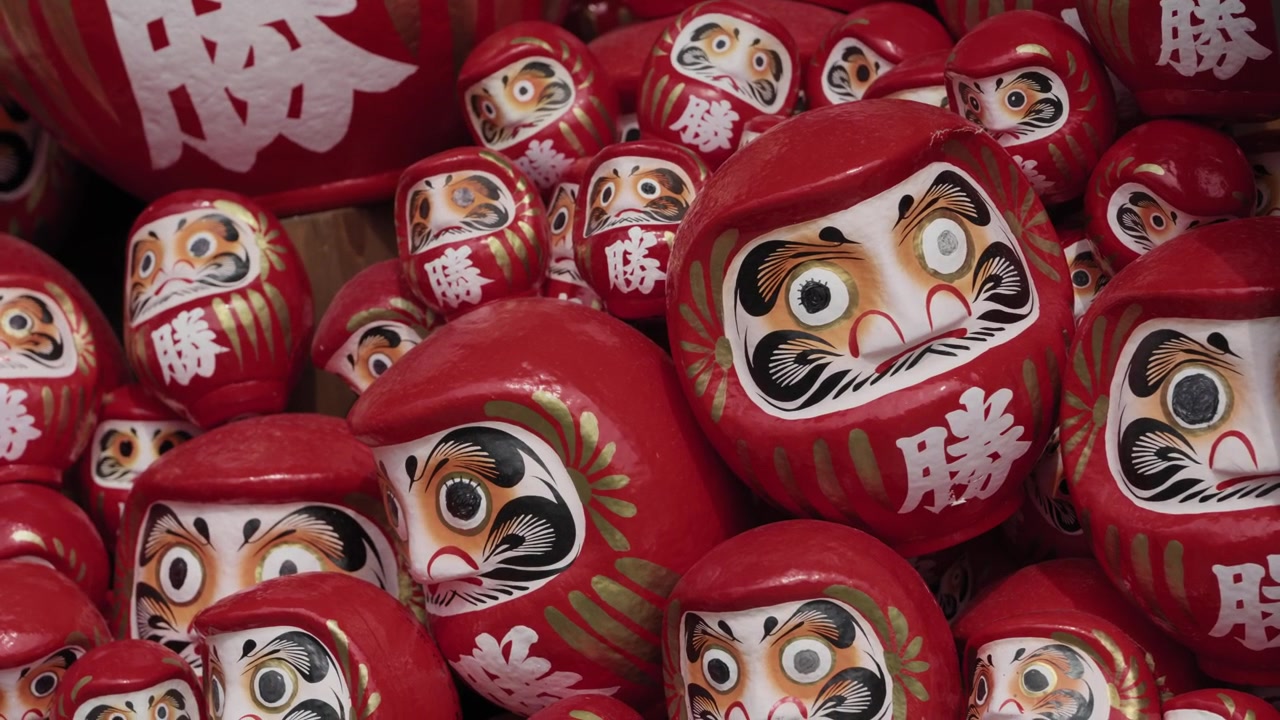 Primo piano di bambole portafortuna Daruma rosse ammucchiate al Tempio Katsuoji a Osaka, Giappone.
