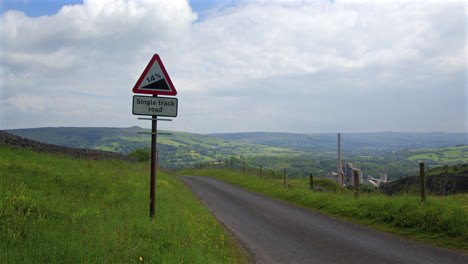 single track road with steep gradient sign in a rural valley landscape
