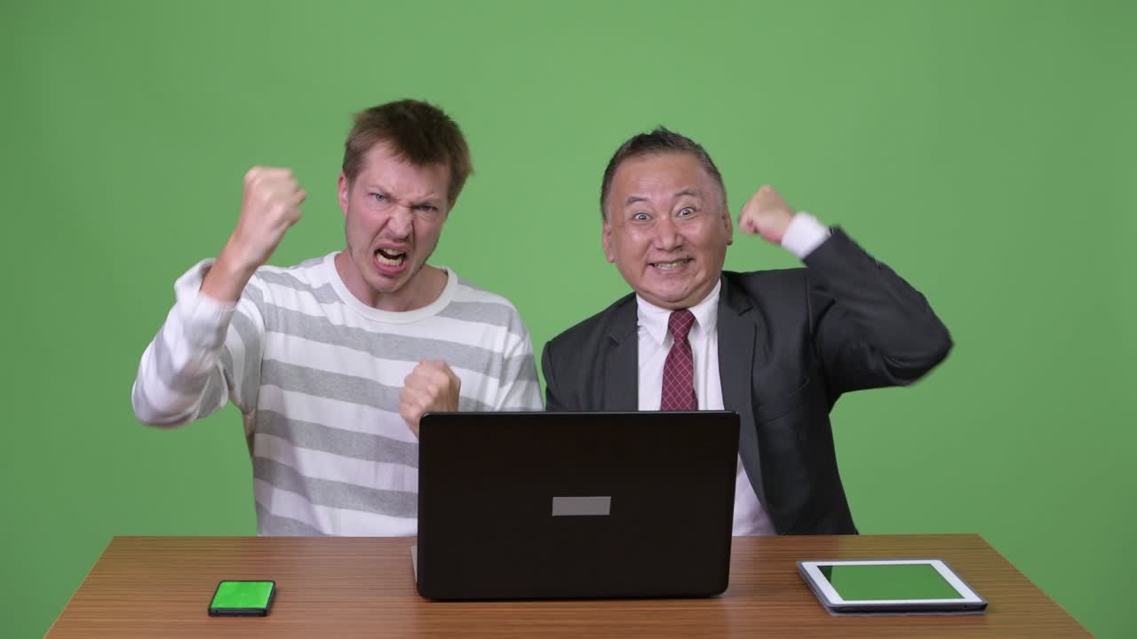 성숙한 일본 사업가와 젊은 스칸디나비아 사업가가 함께 일하고 있습니다.