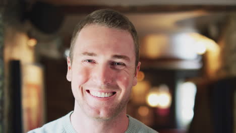 Head-And-Shoulders-Portrait-Of-Smiling-Man-Inside-Hotel