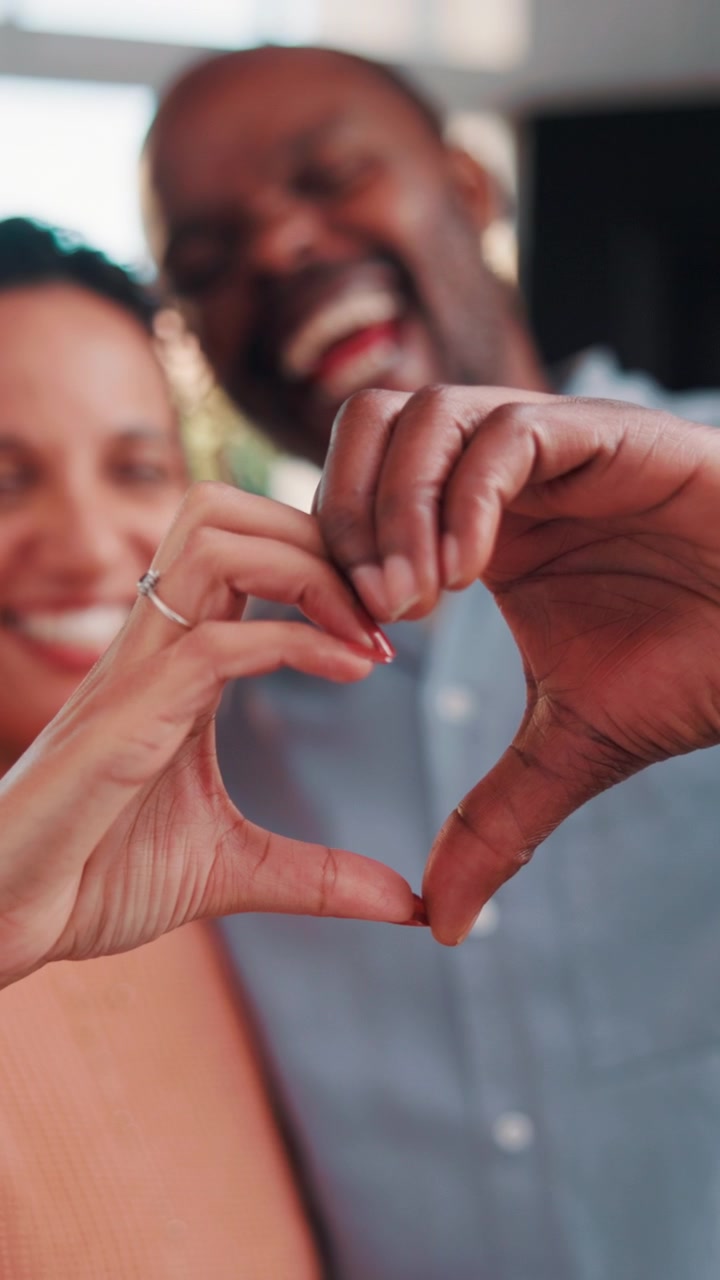 Coppia felice che forma un cuore con le mani