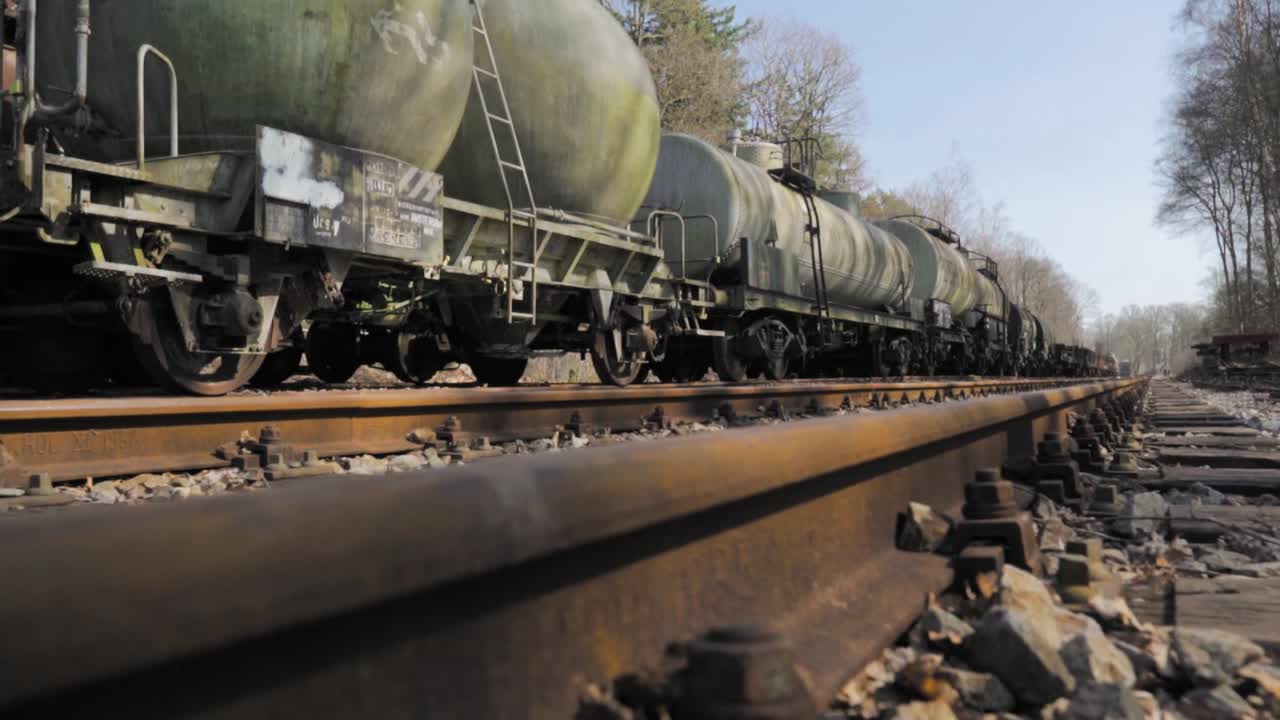 viejos vagones cisterna en las vías de ferrocarril oxidadas en el bosque