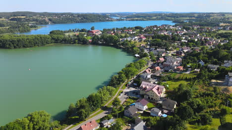 aerial backwards shot of natural lake,road with cars and small village near gdansk,poland