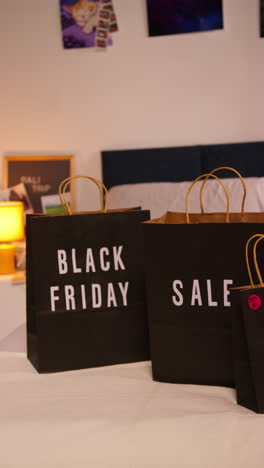 black friday shopping bags on a bed