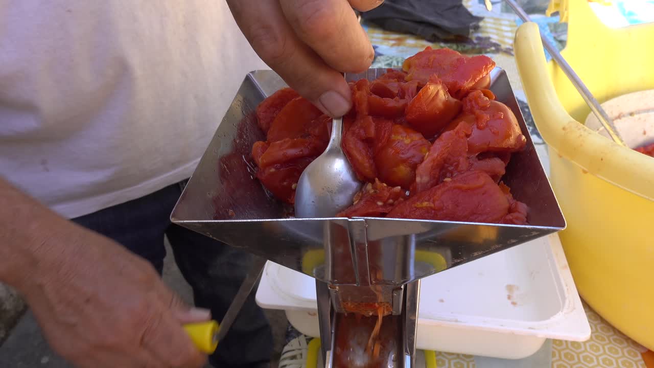 Taze haşlanmış domateslerle domates sosu yapma makinesinin doldurulması