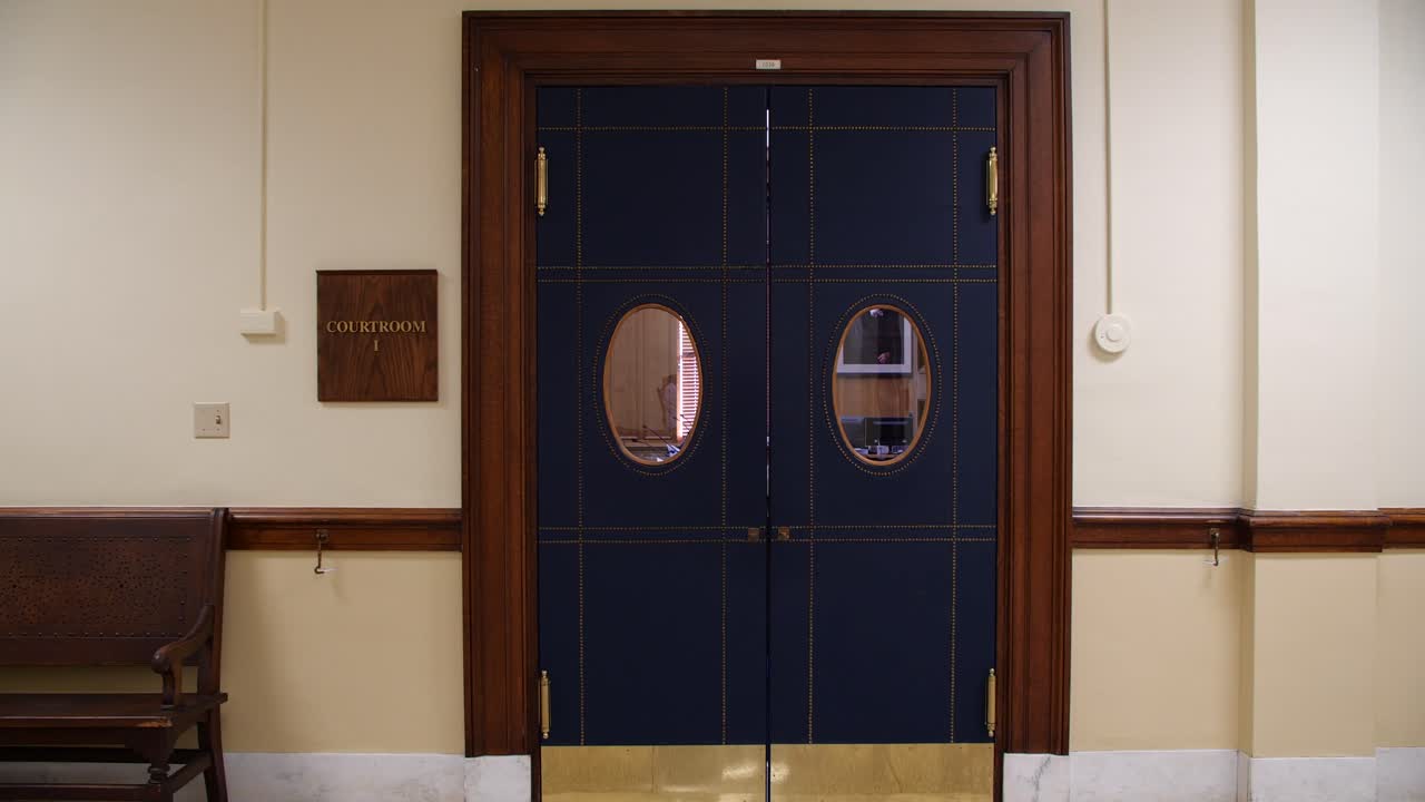4k Courtroom trial doors leading into court room with sign on wall in courthouse lobby wide shot for b roll