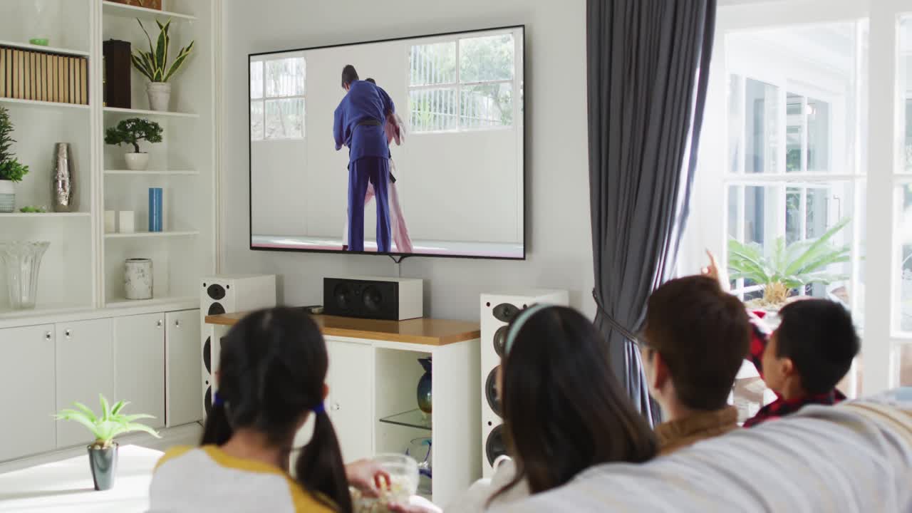 집 에서 함께 앉아 tv 에서 유도 경기 를 시청 하는 행복 한 가족 의 합성