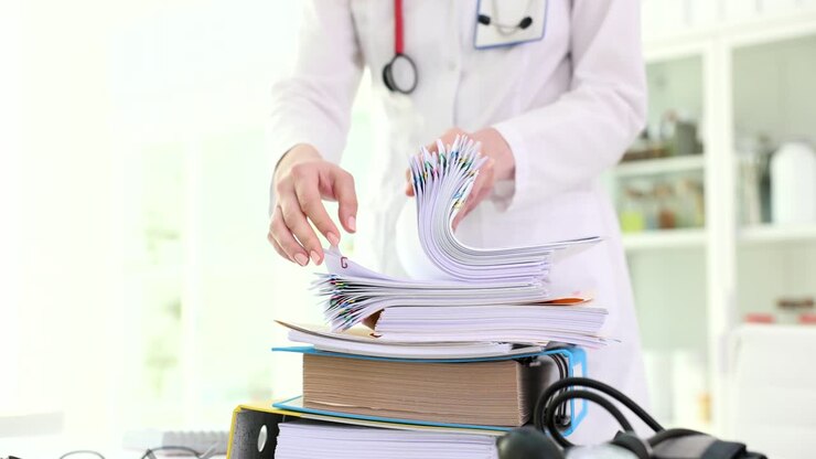 Medical professional organizing patient files and documents