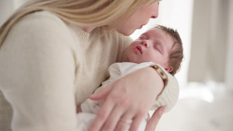 Family,-kiss-and-a-mom-rocking-her-baby-to-sleep