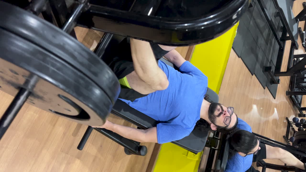 Latin man with long hair and beard performing leg press 45 exercise