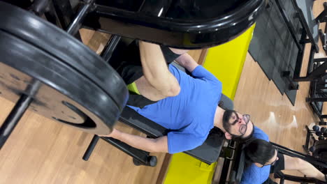 hombre latino con pelo largo y barba realizando un ejercicio de presión de piernas 45