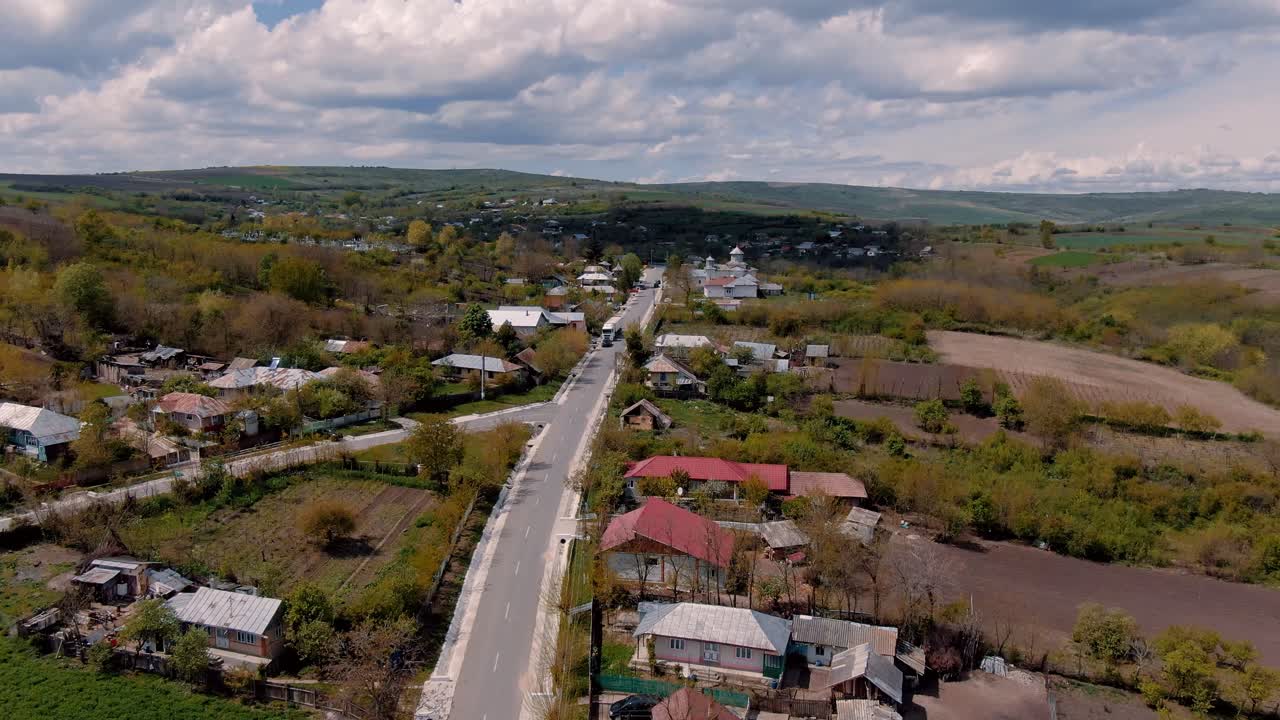 Vista aerea su un'antica strada di paese e case, campi agricoli, chiesa, parzialmente nuvoloso, giornata di sole