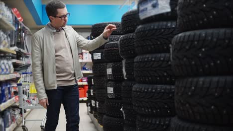 man choosing winter tires in a store