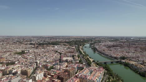 drone volando sobre el famoso río guadalquivir en el centro de la ciudad de sevilla