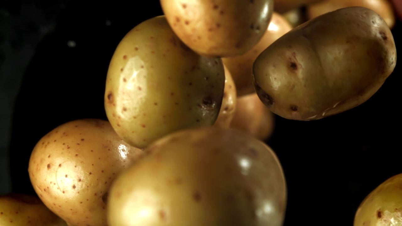 Patate fresche e crude con goccioline d'acqua che cadono in super rallentatore