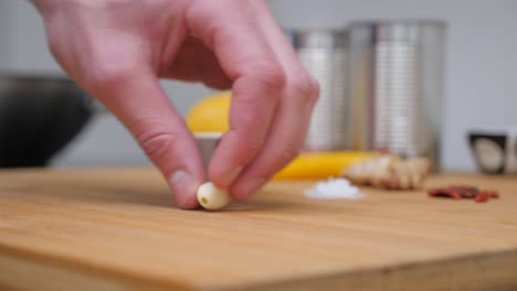 person cutting garlic cloves, static close up