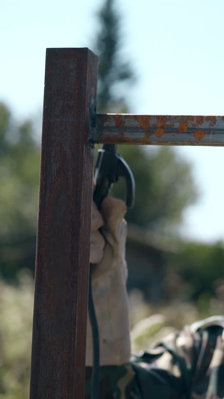 professional welder in protective mask and gloves fixes long metal plank to fence top with equipment