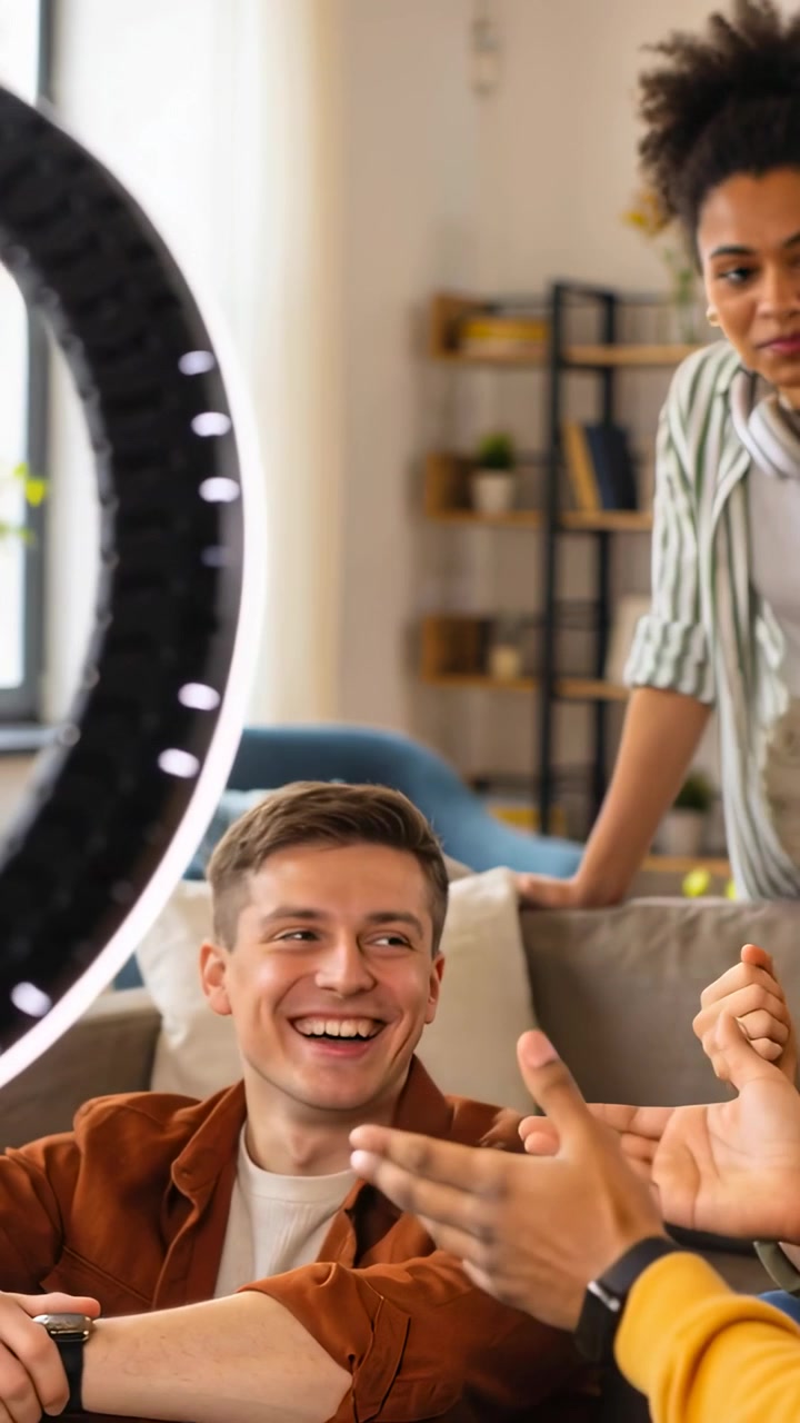 Vertical video: Reacting to offscreen clap, man speaking, laughing during home stream, ring light
