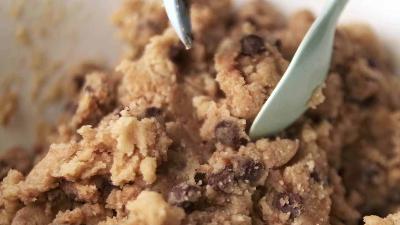 super macro primer plano de mezclar masa de galletas con trocitos de chocolate en un tazón