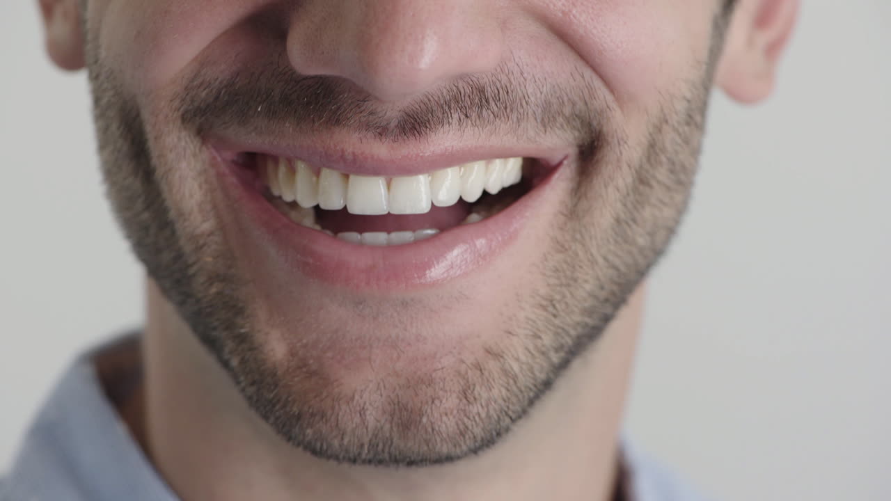 cerca la boca del joven sonriendo feliz con la barba concepto de salud dental mitad de la cara