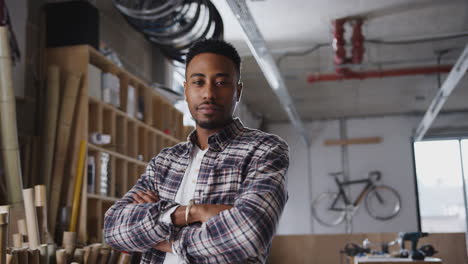 Portrait-Of-Young-Male-Business-Owner-In-Workshop-For-Building-Sustainable-Bamboo-Bicycles