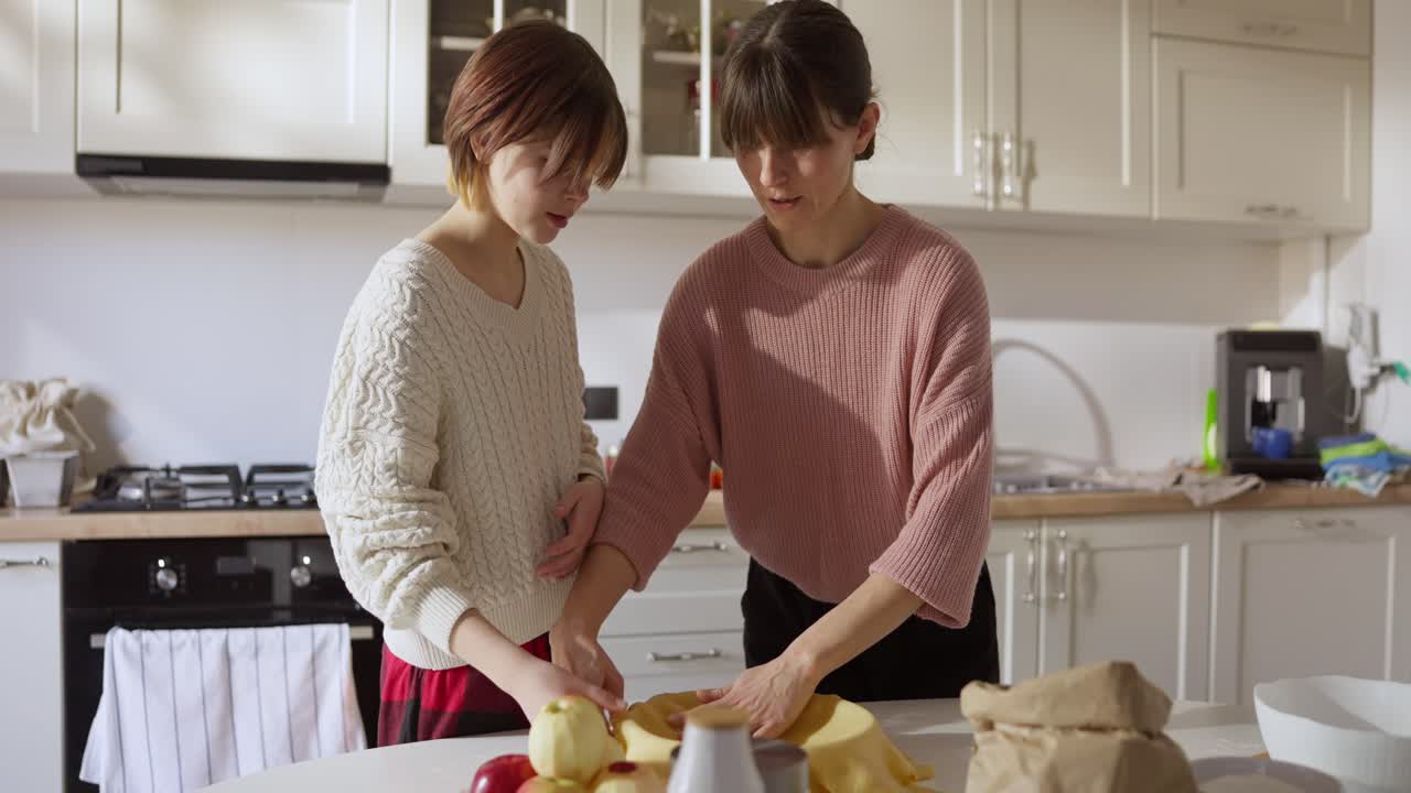 Mother and Daughter Baking Pie Together in Kitchen