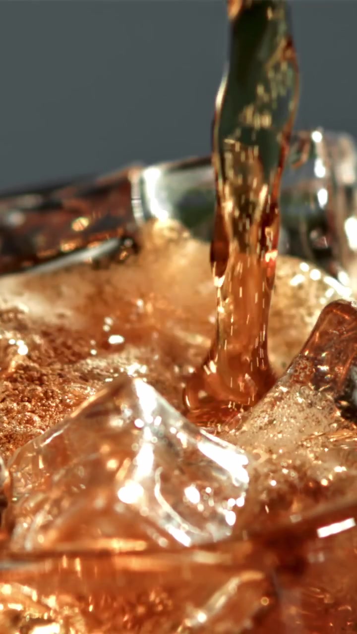 Bevanda rinfrescante alla cola versata sul ghiaccio in un bicchiere.