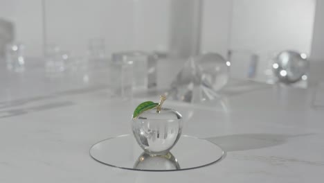 manzana de vidrio de cristal en la parte superior de un espejo que brilla a través de la luz