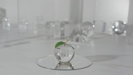 crystal glass apple on top of a mirror shinning light through