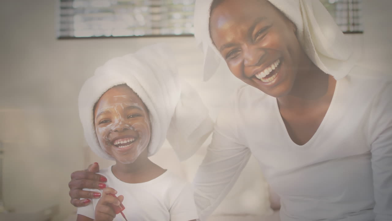 얼굴 마스크를 착용한 행복한 아프리카계 미국인 어머니와 딸 위에 반이는 반점들의 애니메이션