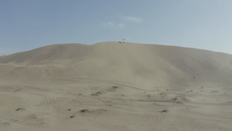 paragliders resting, showcasing an aerial view of vast sand dunes