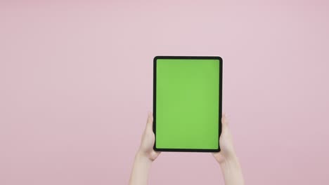 tableta digital con pantalla de teclas cromadas y que se muestra en el fondo rosado.