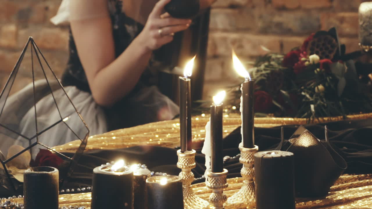 Woman with candle. Young witch woman casts a spell with candle in a room