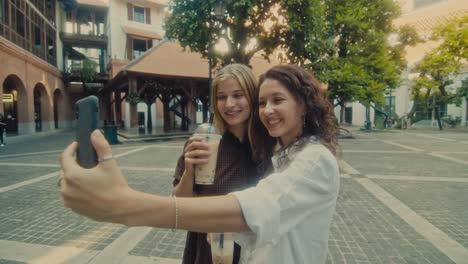 two friends taking a selfie in a city square