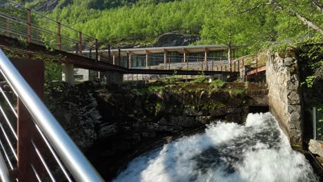 Norwegian-Fjord-Center-and-Geiranger-river-seen-from-popular-walkway-bridge---Tourists-point-of-view---Handheld-stabilized-realistic