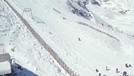 drone flyover snowy slope with skiers and snowboarders at farellones ski resort chile