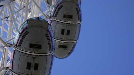 ferris wheel cabins against clear blue sky